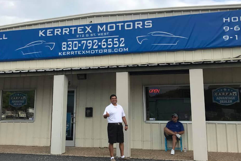 Andy Sanchez, owner of KerrTexMotors, standing in front of the dealership.